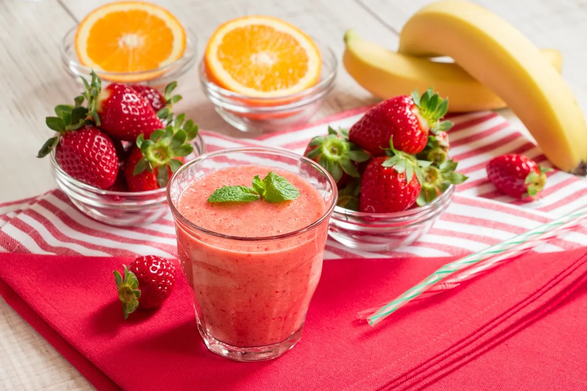 Strawberry smoothie surrounded by fresh fruit
